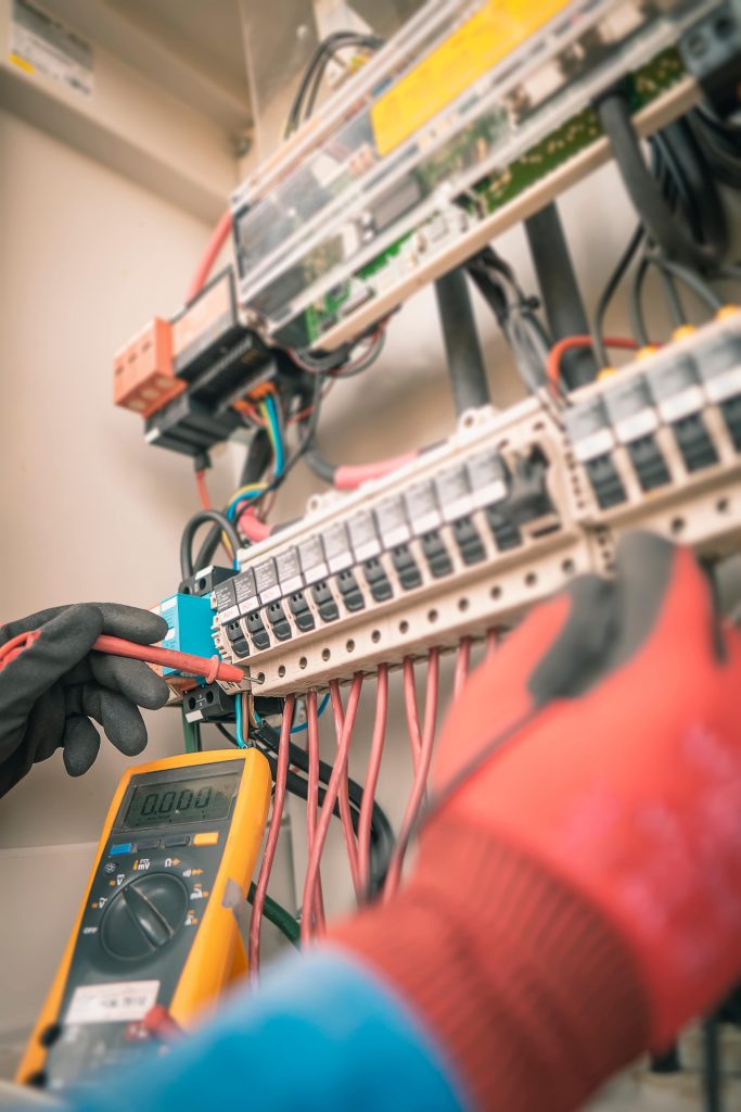 An electrician is working on an electrical panel